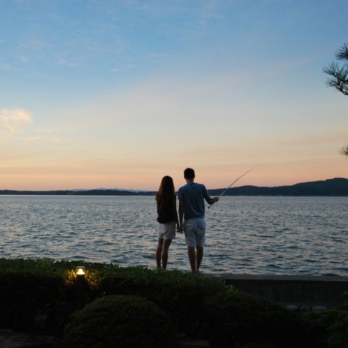和倉温泉ゆけむりの宿美湾荘(七尾市)の中庭の堤防で釣りをするカップル