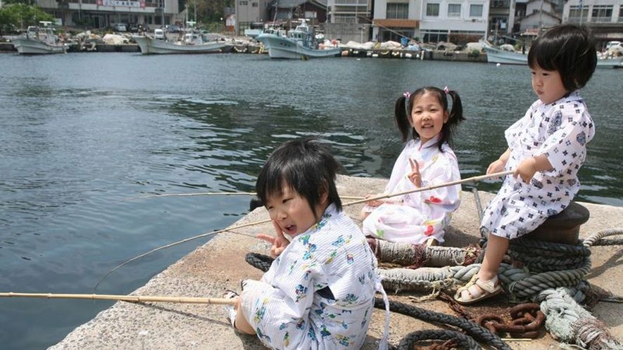 国文化財の宿旅館美保館（松江市）の前で竹竿で釣りしている子供達