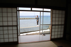 民宿西湾荘(七尾市)の部屋のすぐ近くの堤防で釣りをしている店主