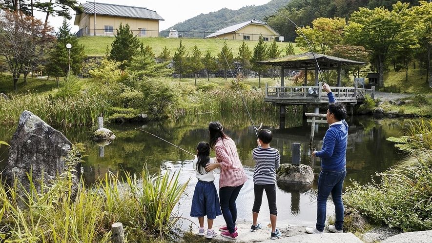 たかむろ水光園（遠野市）の敷地内釣り堀で釣り体験する家族